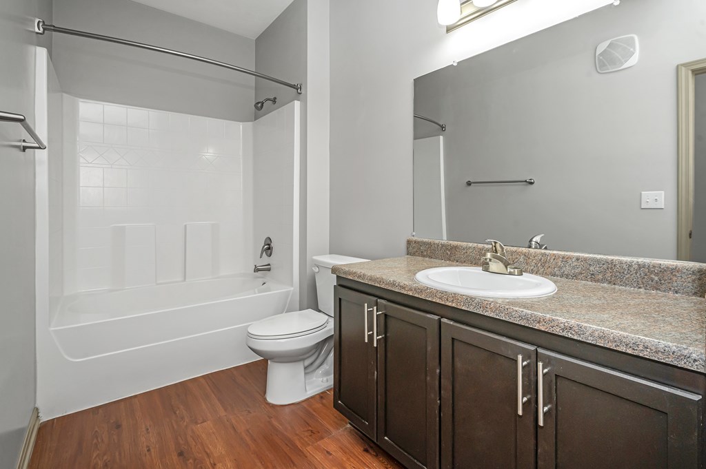 A bathroom with a white toilet and a white shower.